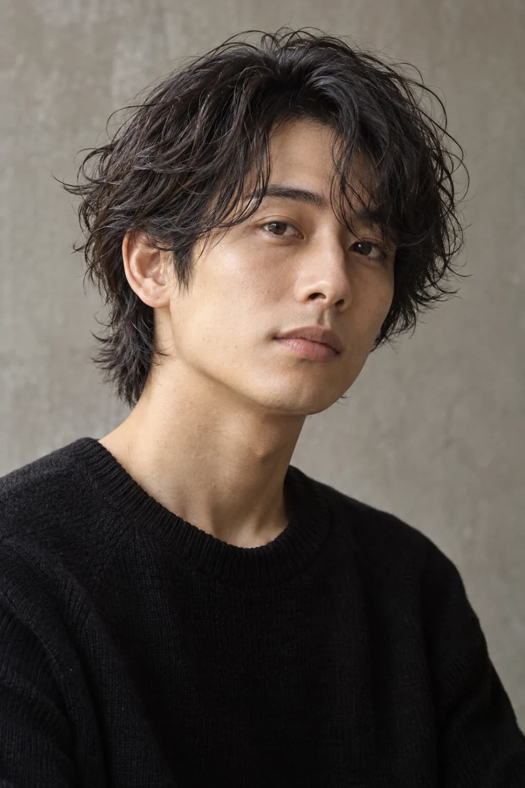自然な動きのある黒髪とゆるい前髪の、メンズミディアムヘアのモデルイメージ